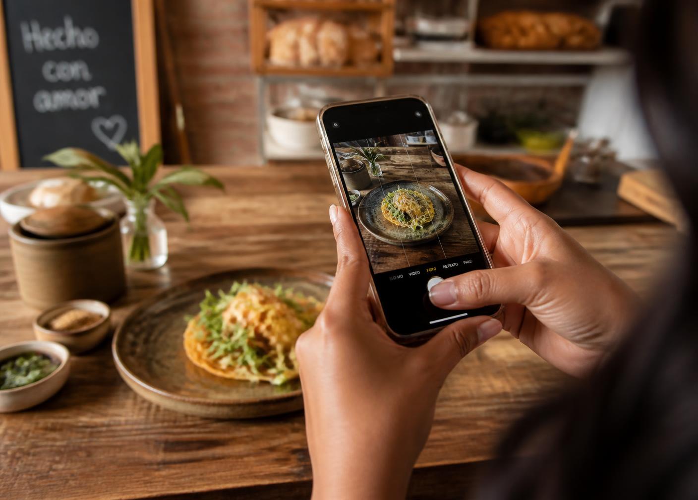 Emprendedora gastronómica fotografiando un platillo de su negocio